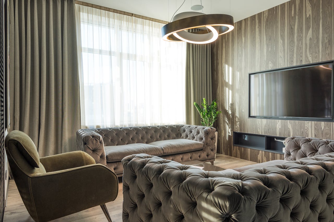 Interior of modern room with soft furniture near TV set and huge window